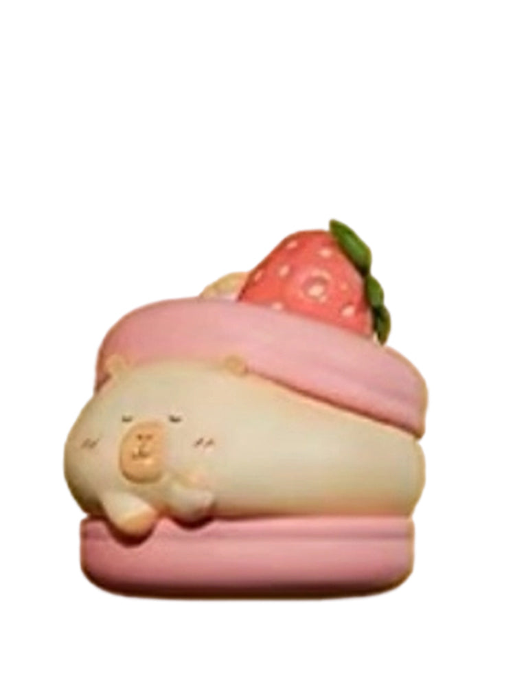 Macaroon capybara mini figure lying on a pink macaron topped with a strawberry, from the Tuntunzai Bakery series