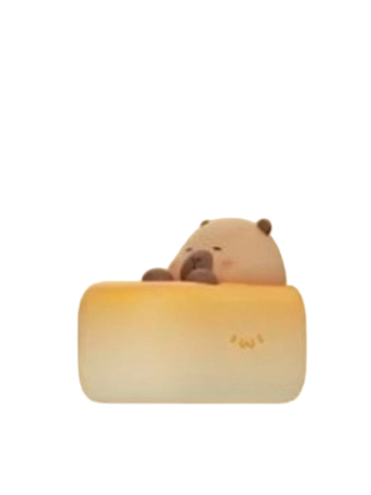 Cheesecake capybara mini figure resting on a slice of cheesecake, from the Tuntunzai Bakery V2 series