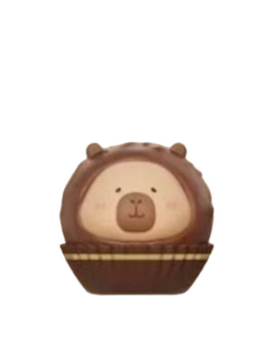 Chocolate Chips capybara mini figure inside a round chocolate chip bonbon in a paper cup, from the Tuntunzai Capybara Chocolate series